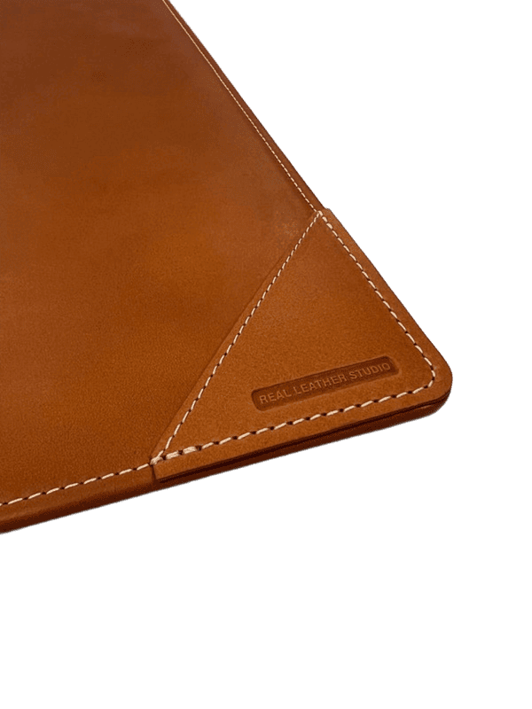 Primer plano de la esquina del vade mostrando las costuras artesanales y la calidad de la piel.