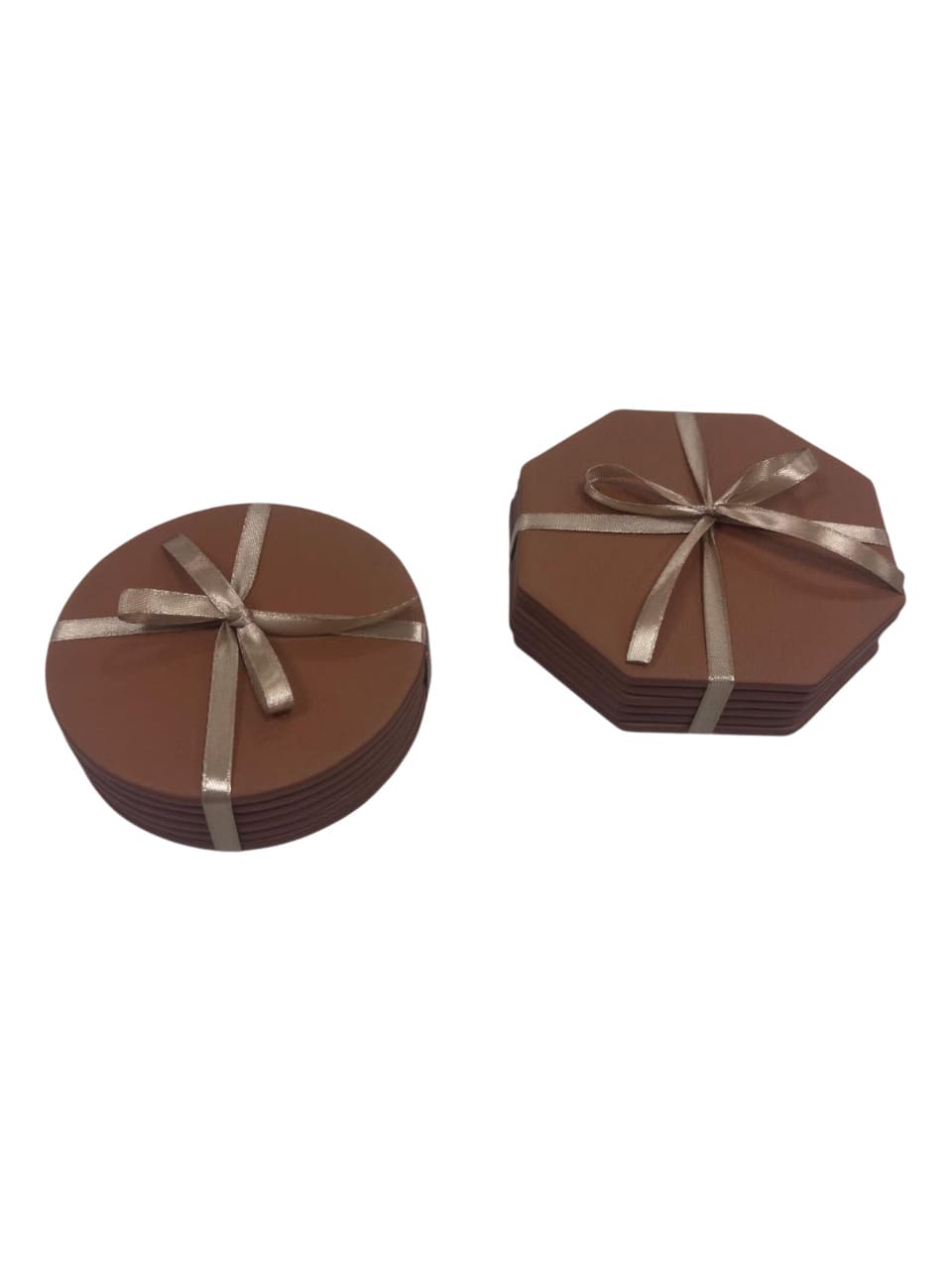 Posavasos octogonales de piel junto a modelo circular en color marrón.