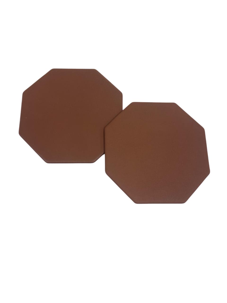 Vista superior de dos posavasos octogonales de piel mostrando la textura del cuero.