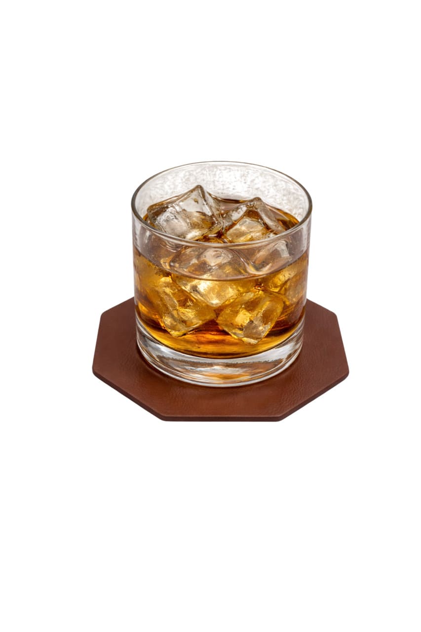 Posavasos octogonales de piel protegiendo una mesa de madera de un vaso frío