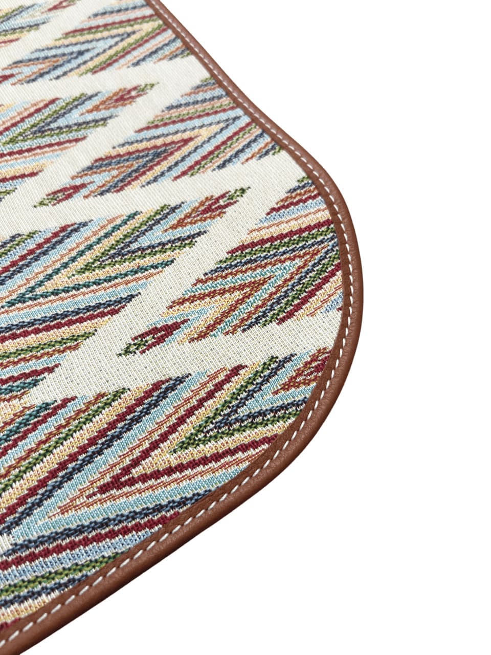 Close-up of the durable canvas texture and leather trim edge of the pet feeding mat.